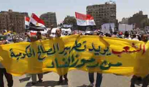 Des manifestants défilent au Caire, portant une bannière exigeant que les institutions gouvernementales soient débarrassées de toute corruption. 