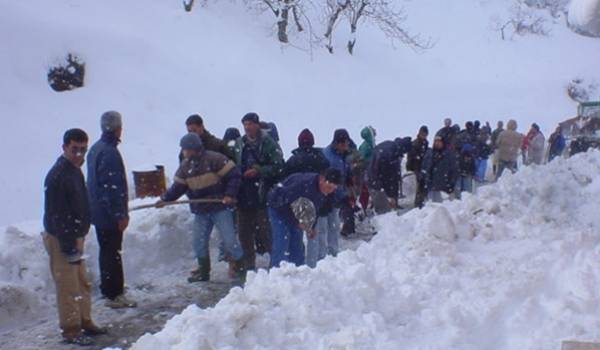 Les jeunes Kabyles dégagent la route bloquée par la neige.