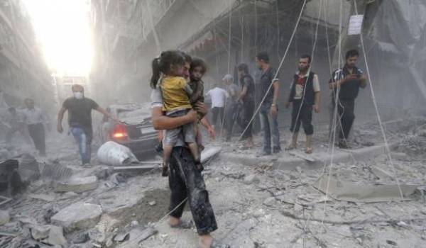 Un Syrien avec ses deux filles dans Alep sous les bombardements.